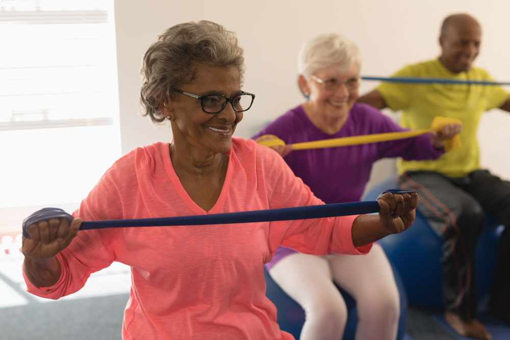 Three older adults exercising using resistance bands