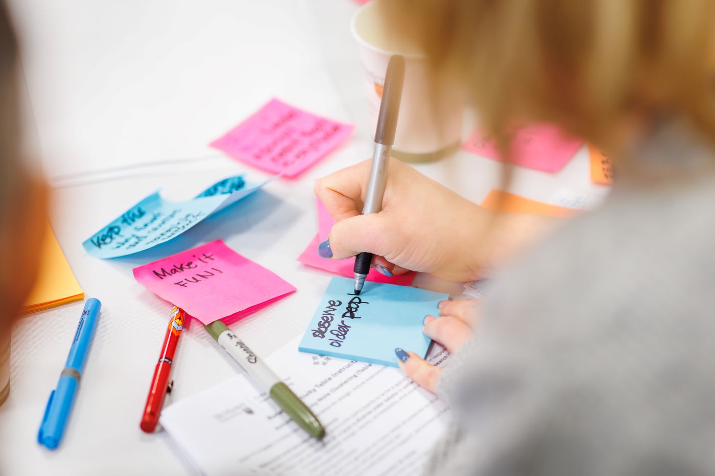 Close up of person writing on sticky notes